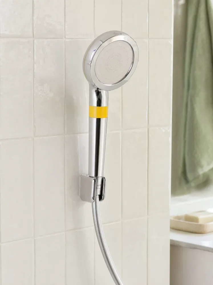 The shower head seated in a wall holder on white tile (hose and holder not included)